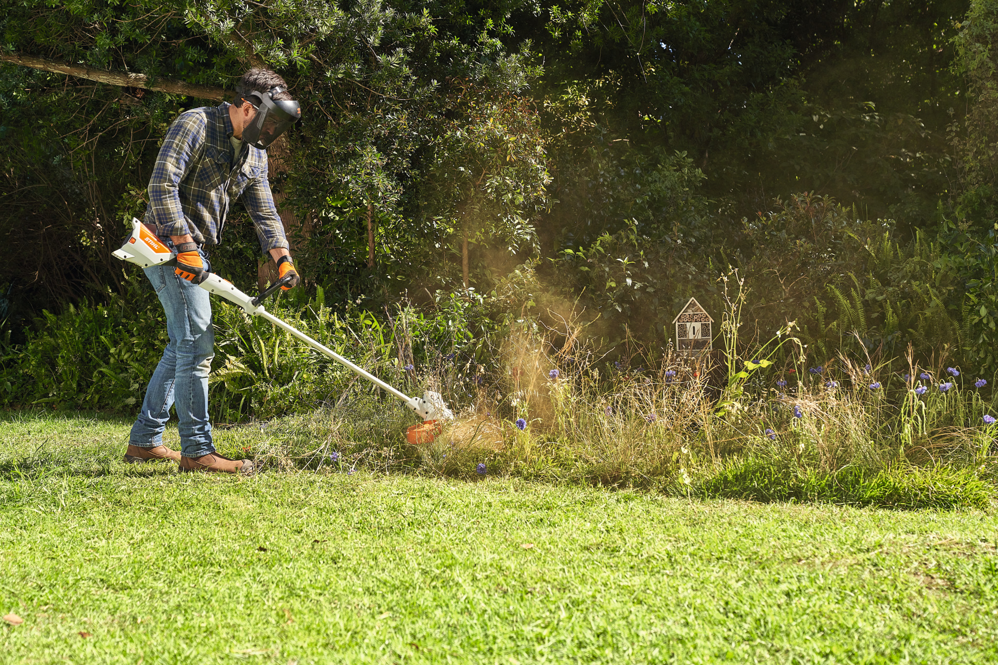 Férfi STIHL FSA 57 készülékkel egy vadvirágos réten