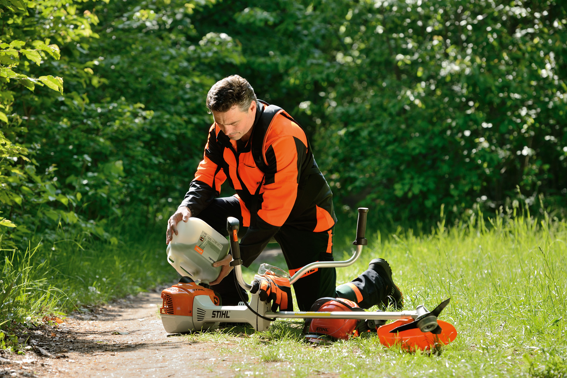 Egy férfi benzin-olaj keverékkel tankolja fel a STIHL motoros kaszát