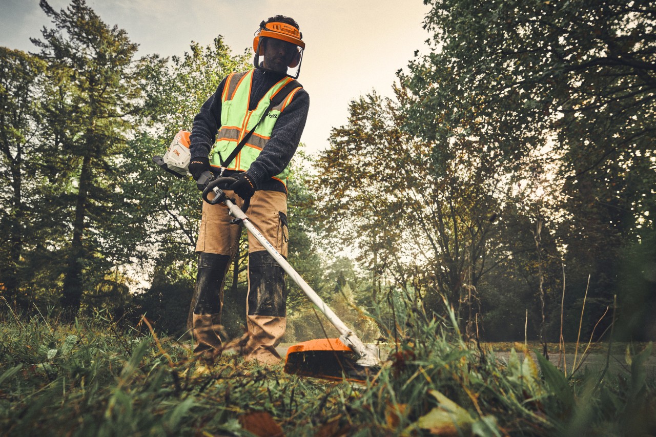 Egy férfi STIHL KMA 200 R-rel és FS-KM kombiszerszámmal